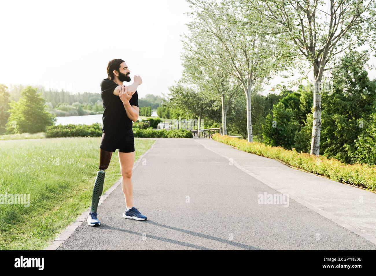 Sportler mit Beinprothesen-Dehnung vor sportlicher Routine in Park City - körperliche Behinderung, gesundes Lifestyle-Konzept Stockfoto