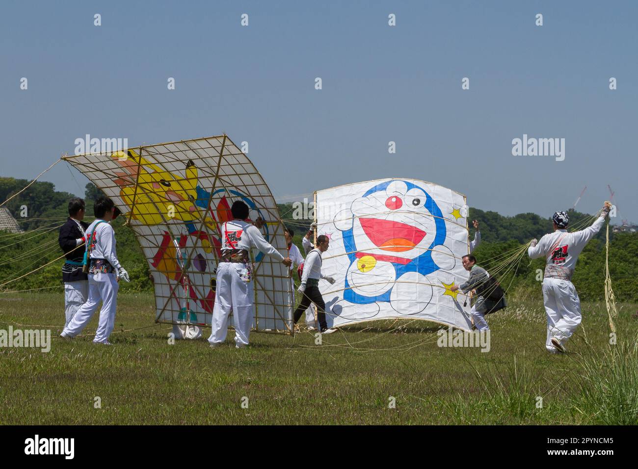 Fans des Festivals Sagami Giant Kite Festival (Sagami-no-Oodako) Sagamihara bereiten Kinderdrachen mit Pokemon auf Doraemon-Figuren zu. Das Sagami Giant Kite Festival begann in den 1830er Jahren als Ergänzung zum Children's Festival, das am 5. Mai in japan gefeiert wird. Mit der Zeit sind die Drachen, die aus Bambus und handgemachtem Papier bestehen, größer geworden. Die größten Drachen, die während dieses Festivals vom Flussufer der Sagami geflogen wurden, sind etwa 15 Meter lang und können über 900 Kilogramm wiegen. Ein Team von 80 bis 100 Personen braucht sie, um sie in die Luft zu jagen. (Foto von D Stockfoto