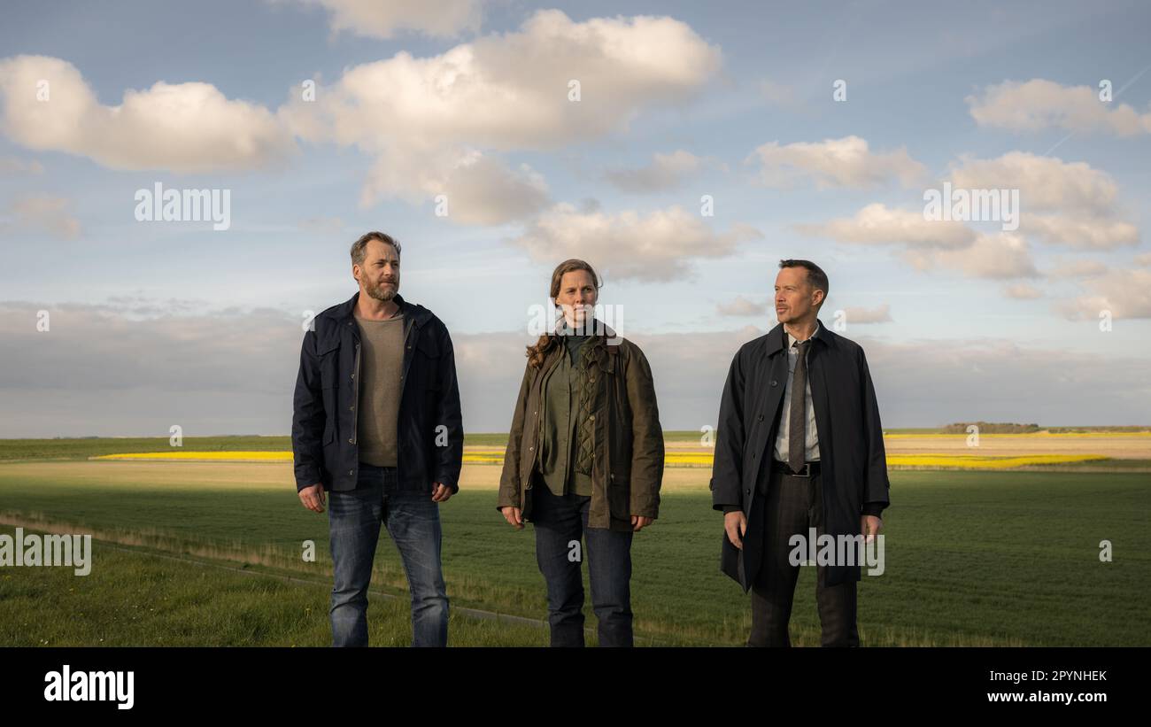 Norden, Deutschland. 03. Mai 2023. Die Schauspieler Christian Erdmann (l-r), Picco von Groote und Barnaby Metschurat stehen auf dem Deich während einer Nachstellung einer Filmszene während eines exklusiven Fototermins als Teil der Dreharbeiten für die ZDF-Serie „Ostfrieslandkrimi“. Kredit: Mohssen Assanimoghaddam/dpa/Alamy Live News Stockfoto