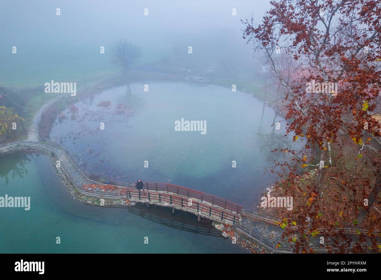 Einsamer Mann in Vryssi Tyrnavou, ein malerischer kleiner See und ein schönes Erholungsgebiet in der Nähe von Tyrnavos Stadt, Larissa, Thessalien, Griechenland. Stockfoto