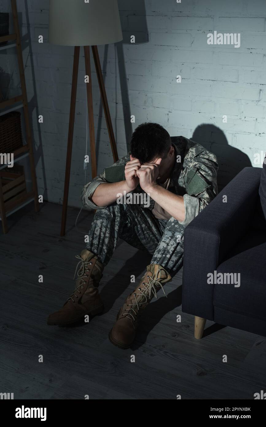 Soldat in Uniform leidet an Dissoziationsstörung zu Hause in der Nacht, Stockbild Stockfoto