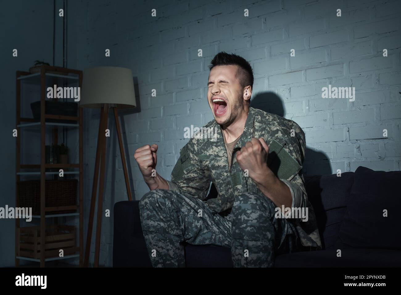 Militärveteran mit psychischen Störungen schreit zu Hause nachts, Stock Image Stockfoto
