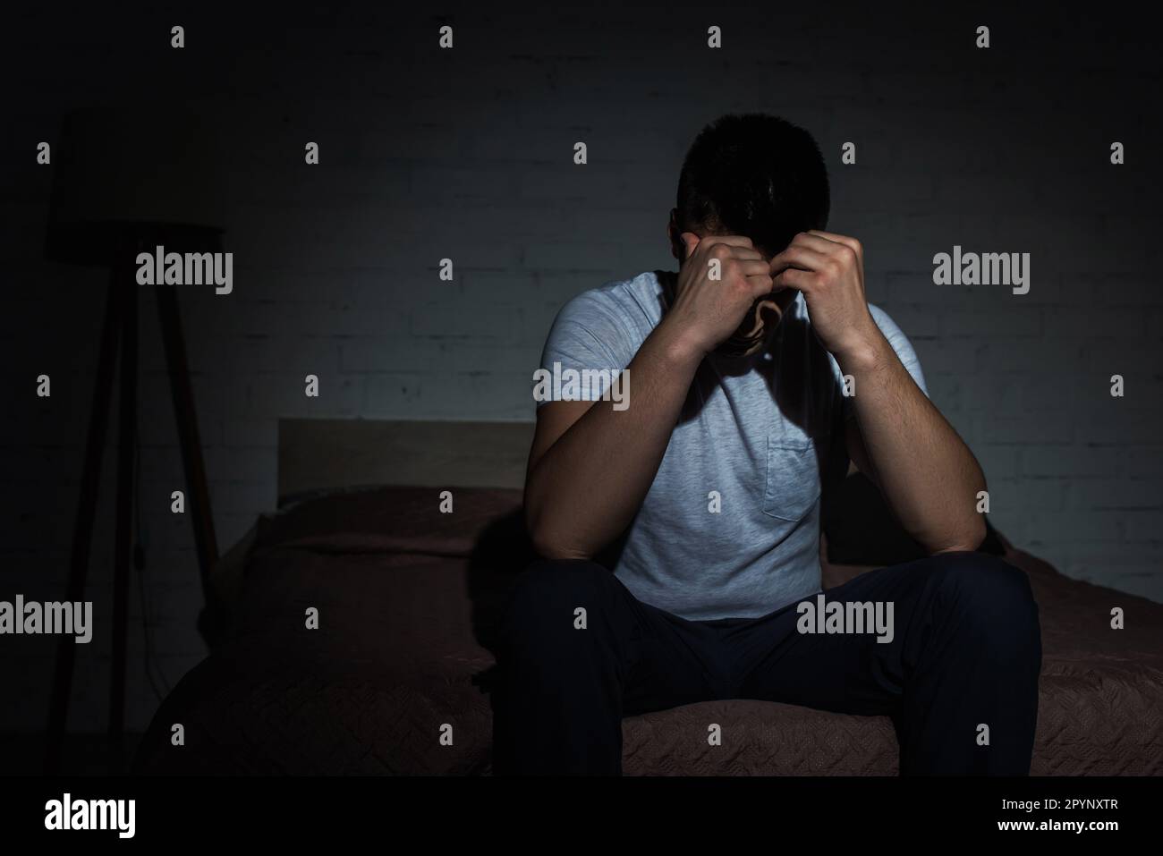 Depressiver Mann mit Schlaflosigkeit, der von posttraumatischer Belastungsstörung kämpft, Stock Image Stockfoto