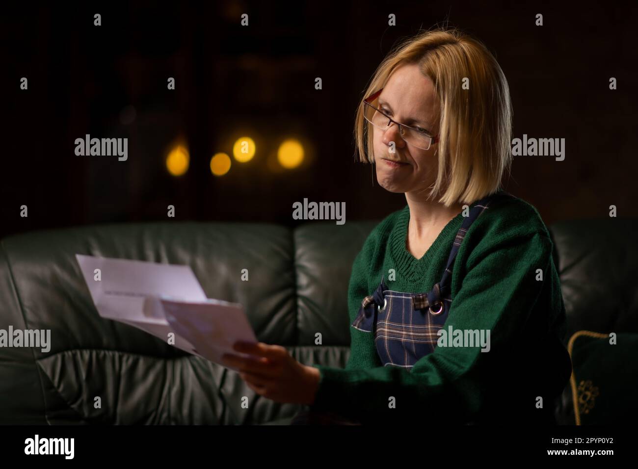 Schlechte Nachrichten in einem Brief. Die Frau ist schockiert über den Inhalt des Briefes. Schulden, schlechte Nachrichten. Stockfoto