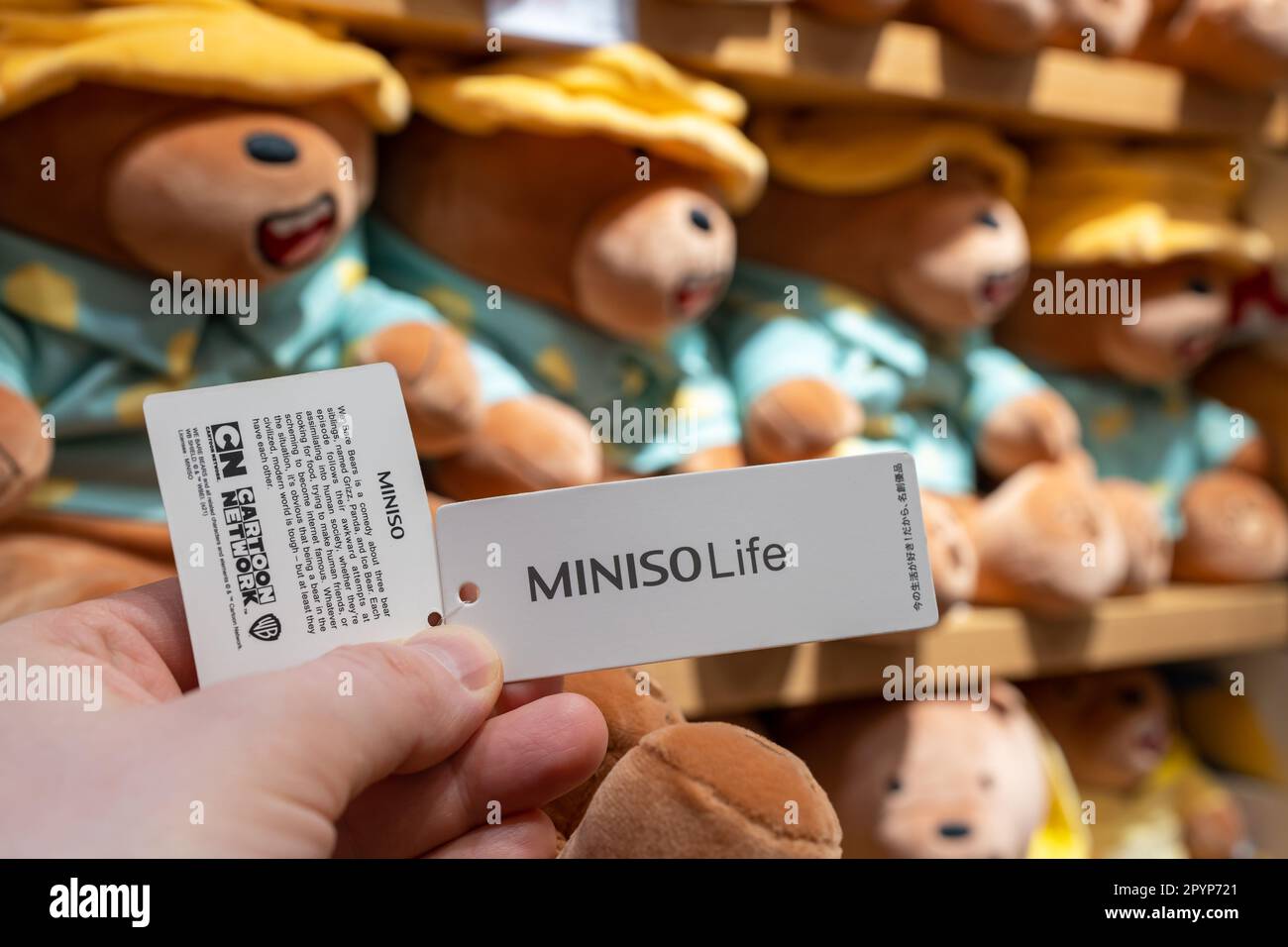 MINISO-Spielzeugetikett mit Firmenlogo in den Händen eines Kunden in einem Geschäft. Minsk, Belarus, 2023 Stockfoto