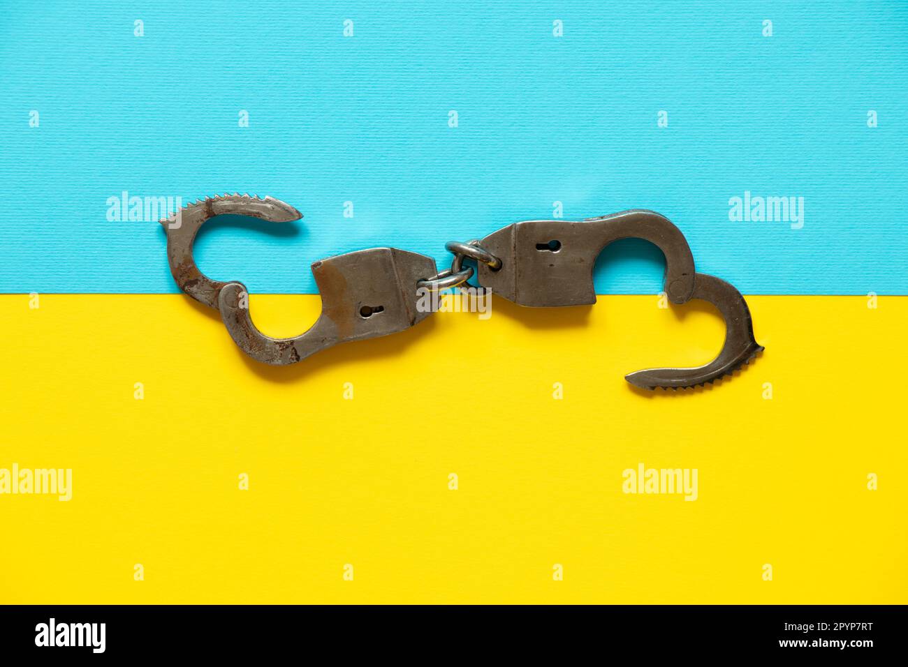 Handschellen liegen auf den Flaggen der Ukraine, Law Stockfoto
