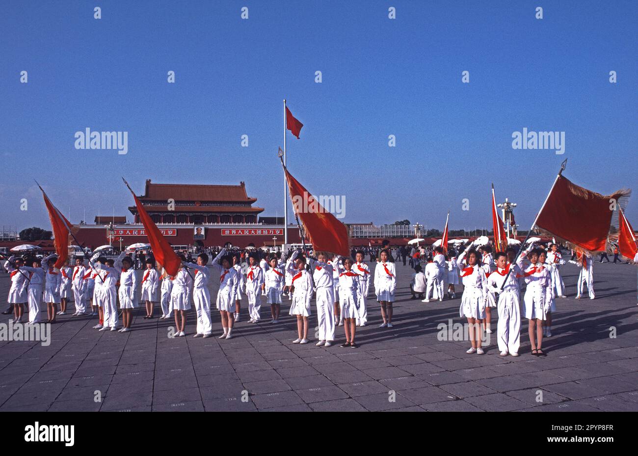 Kinder in Uniformen mit Flaggen zum 35. Jahrestag der kommunistischen Revolution auf dem Platz des Himmlischen Friedens. Peking, China, 1984 Stockfoto