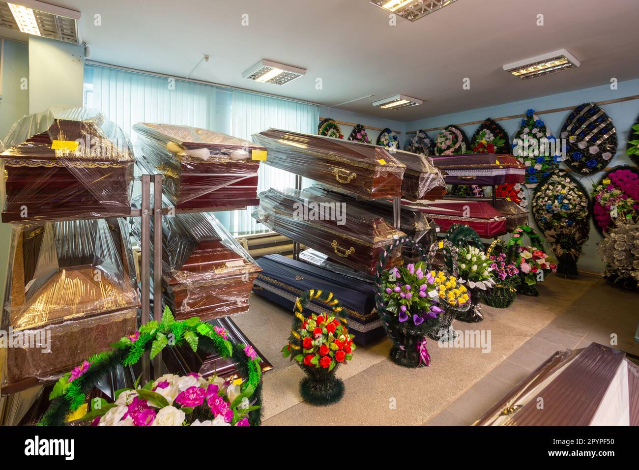 Innenraum des Raumes mit Bestattungszubehör. Geschäft mit Särgen, Beerdigungskränzen und Blumen. Stockfoto