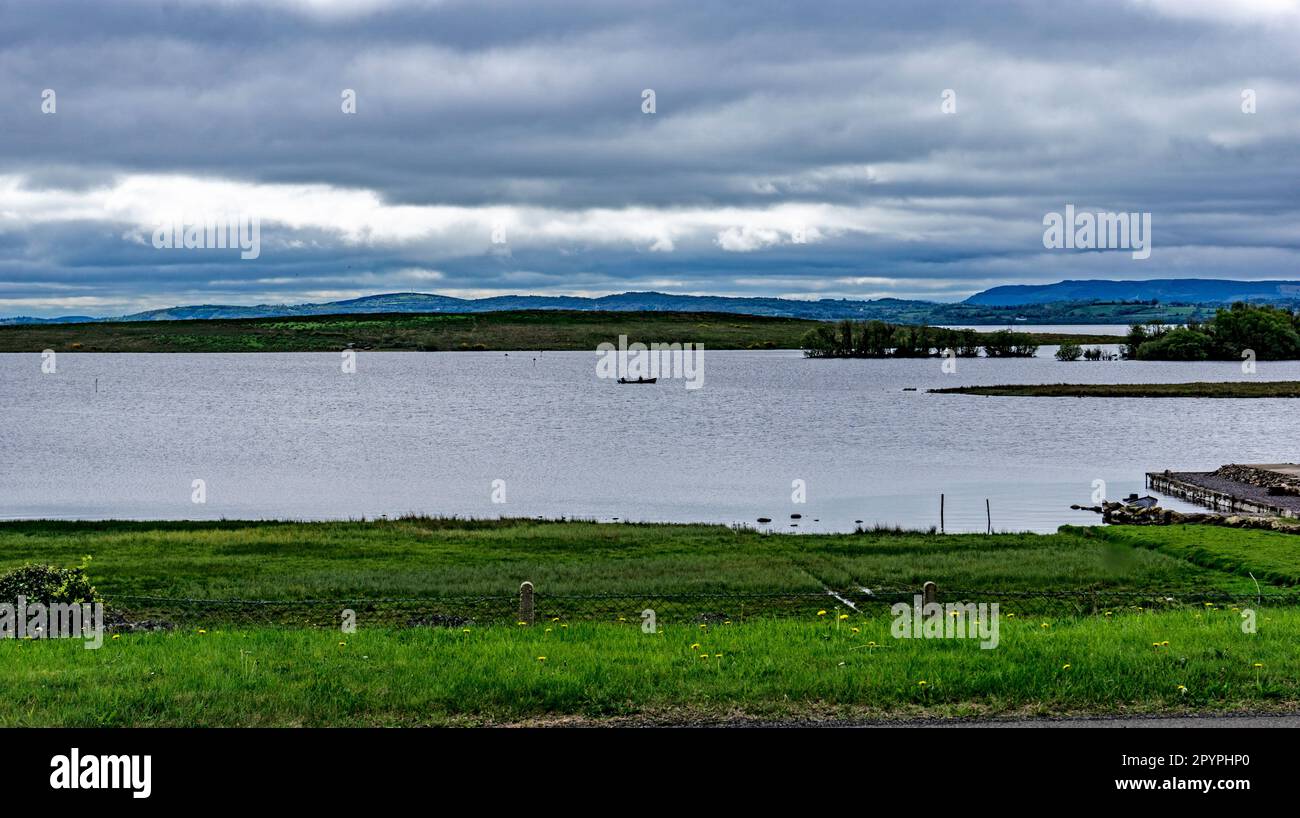Ein Blick auf Lough Erne in Co Fermanagh, Nordirland, während ein kleines Boot die Wasserstraße durchquert Stockfoto