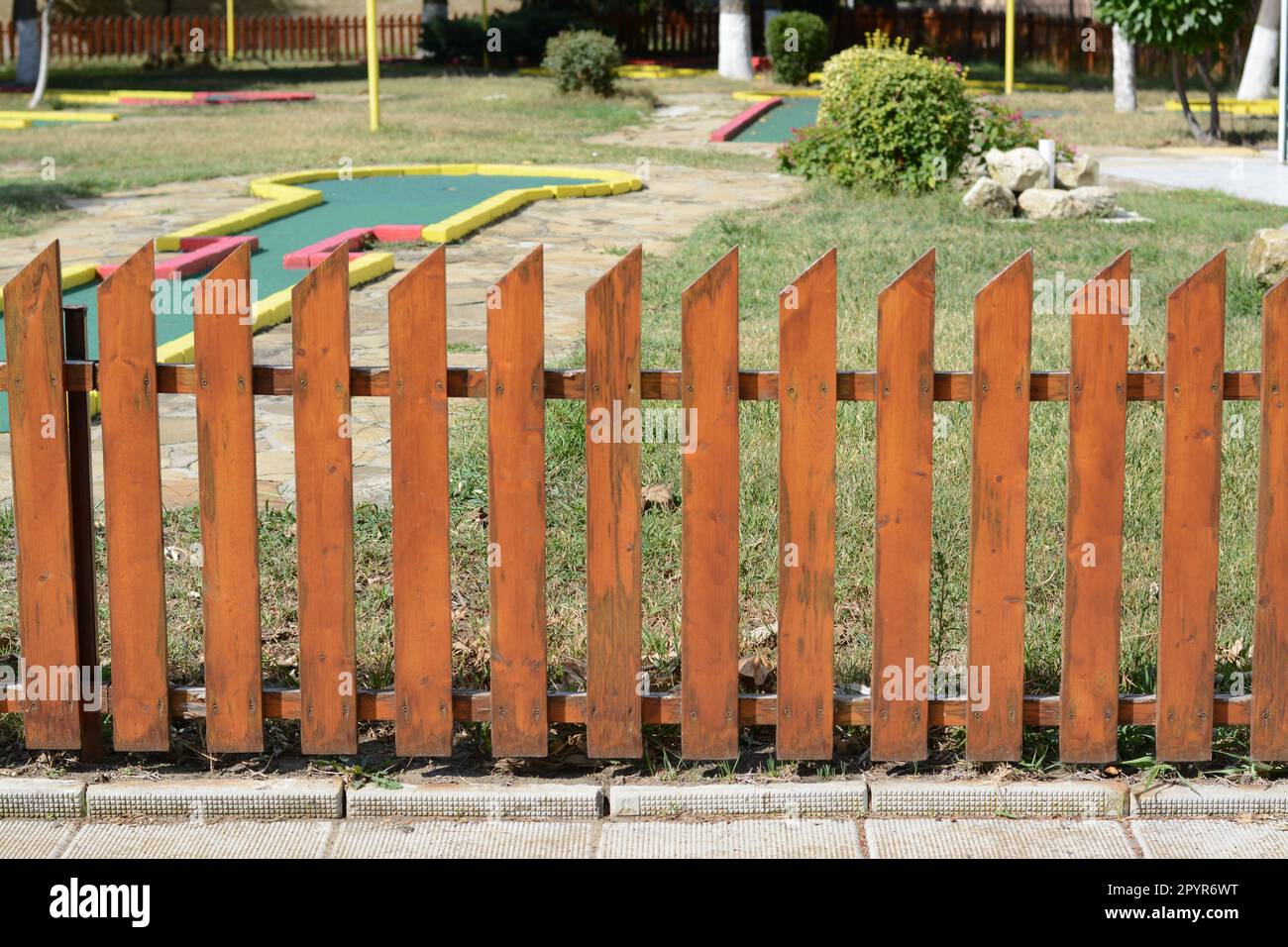 Holzzaun in der Nähe des Minigolfplatzes an sonnigen Tagen im Freien Stockfoto