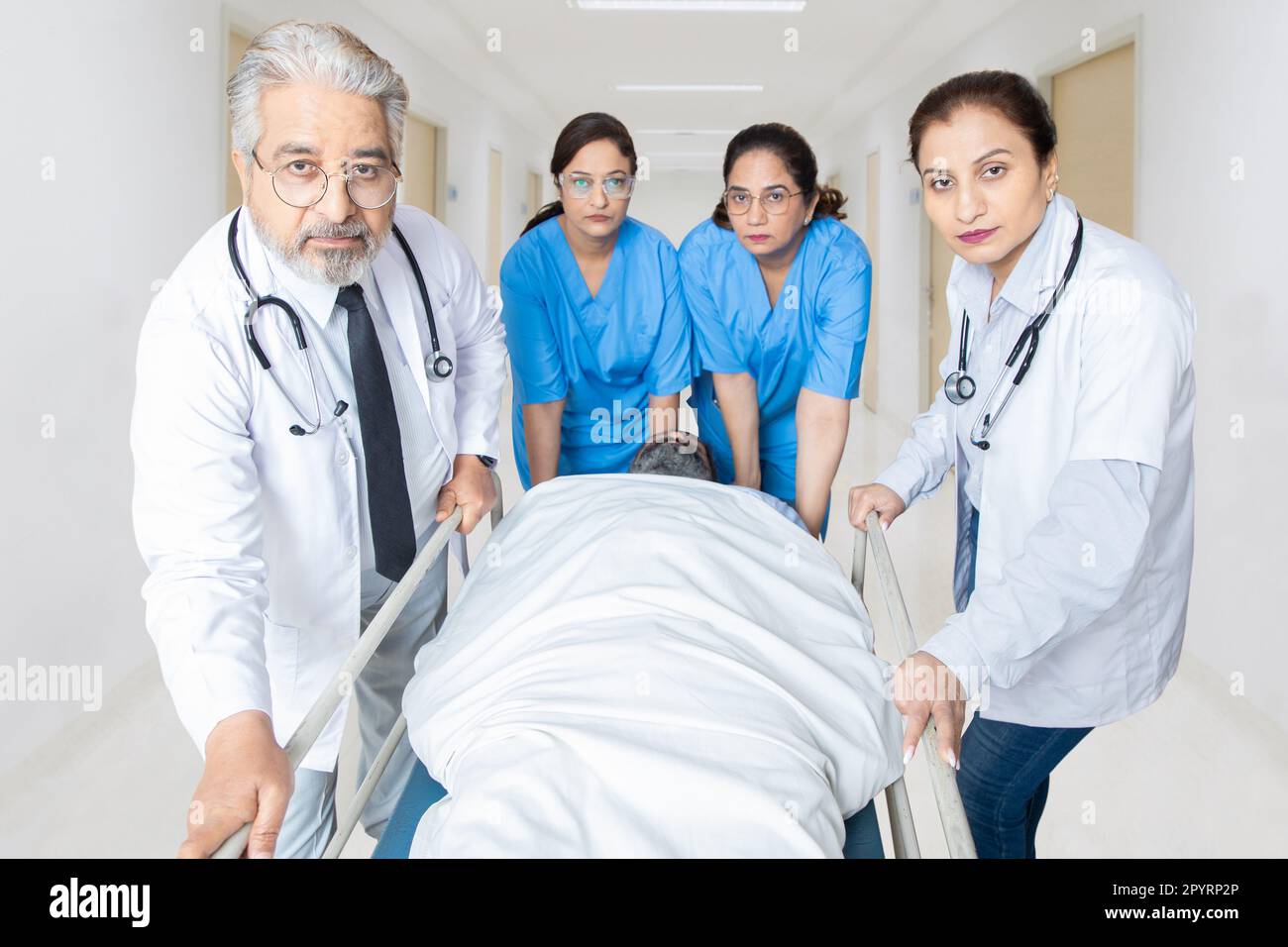 Ein Team von indischer Krankenschwester und Ärztin, die es eilig haben, den Patienten für die Operation zum Operationssaal zu bringen. Schwer Verletzter Patient, Notaufnahme Gesundheit Stockfoto