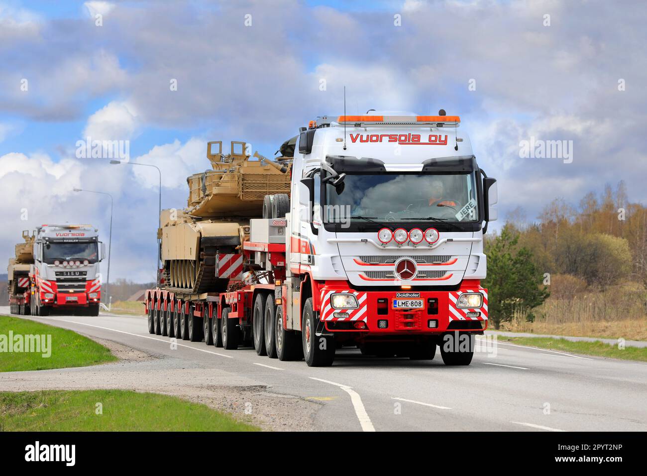 Mercedes-Benz-Lkw transportiert amerikanischen M1 Abrams Militärpanzer auf Auflieger. Konvoi mit 3 außergewöhnlichen Ladungstransporten. Salo, Finnland. 28. April 2023. Stockfoto