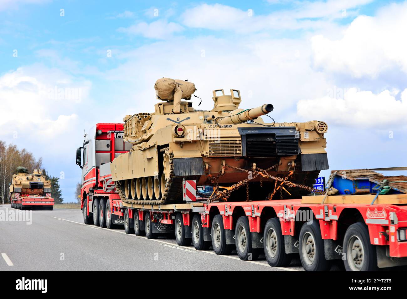 Außergewöhnlicher Ladetransport eines amerikanischen Militärpanzers M1 Abrams im Verkehr. Fahrzeugkonvoi mit drei Panzertransporten. Lieto, Finnland. 28. April 2023. Stockfoto