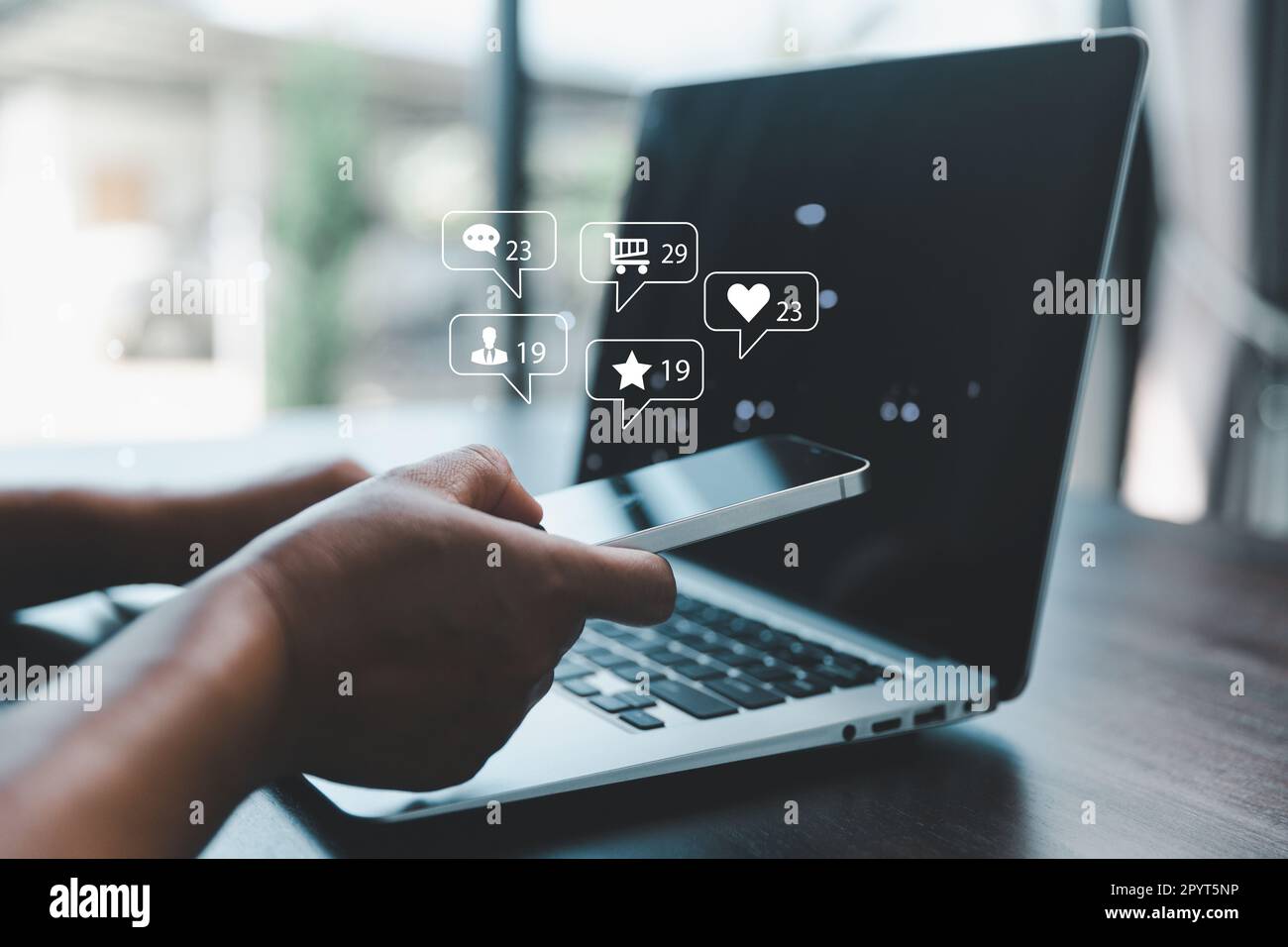 Geschäftsfrau, die ein Smartphone mit Social-Network-Service oder SNS nutzt, Social-Media-Konzept. Frau, die einen Laptop benutzt und zu Hause bleibt, um online zu gehen Stockfoto
