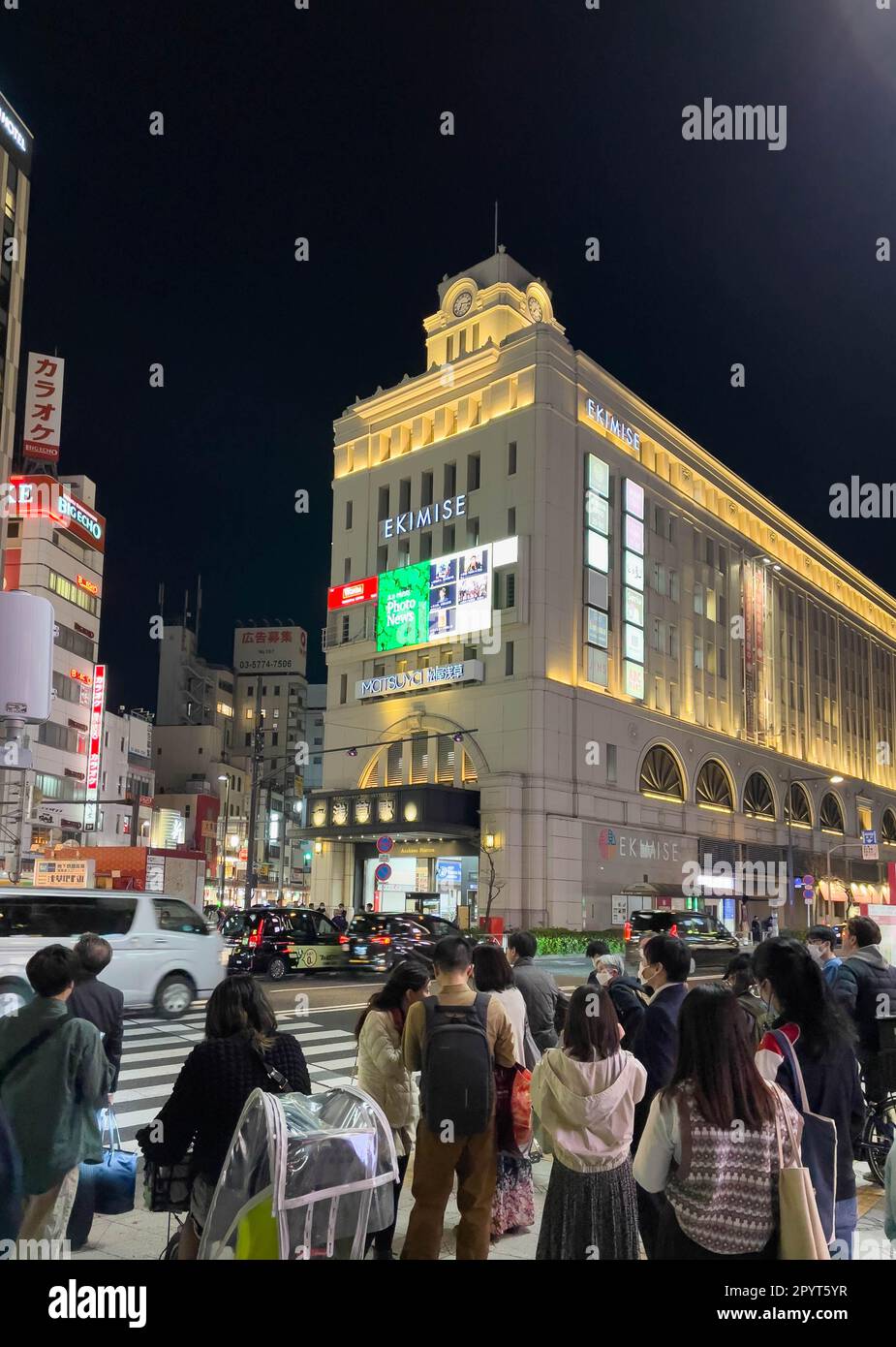 Ein Abendfoto von der Außenseite des Bahnhofs Asakusa, von dem die Tobu-Linie fährt, mit einer großen Gruppe von Touristen, die darauf warten, die Straße zu überqueren. Stockfoto