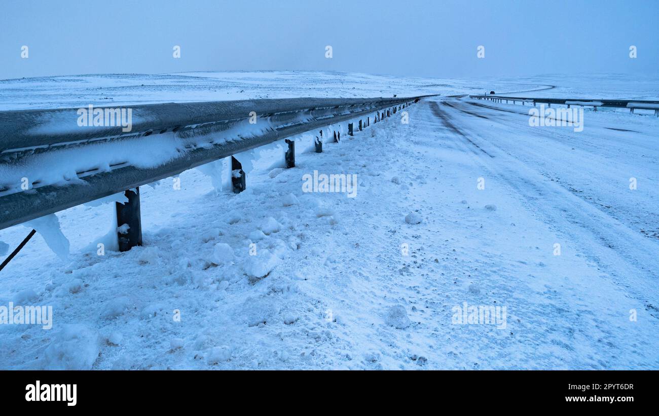 Verschneite Winterstraße ohne Verkehr Stockfoto