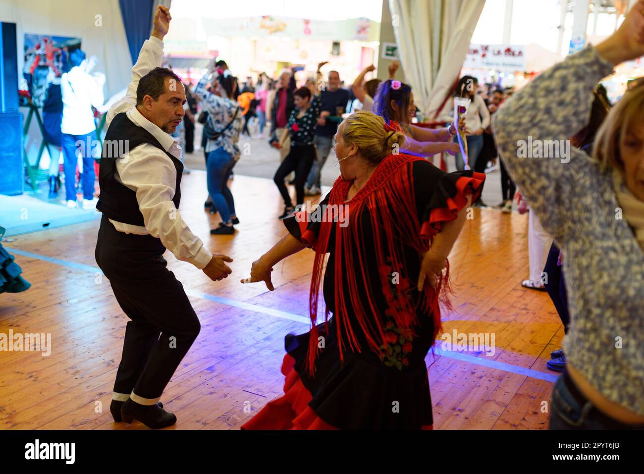 Menschen in traditionellen andalusischen Kleidern werden bei den Festen für die „Feria de Abril“ im Forum Park flamencowährend tanzen gesehen. Der Jahrmarkt, wissen Sie Stockfoto