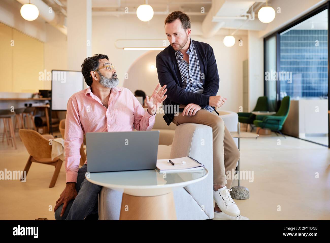 Männliche Unternehmer diskutieren zusammen, während sie im Café sitzen Stockfoto