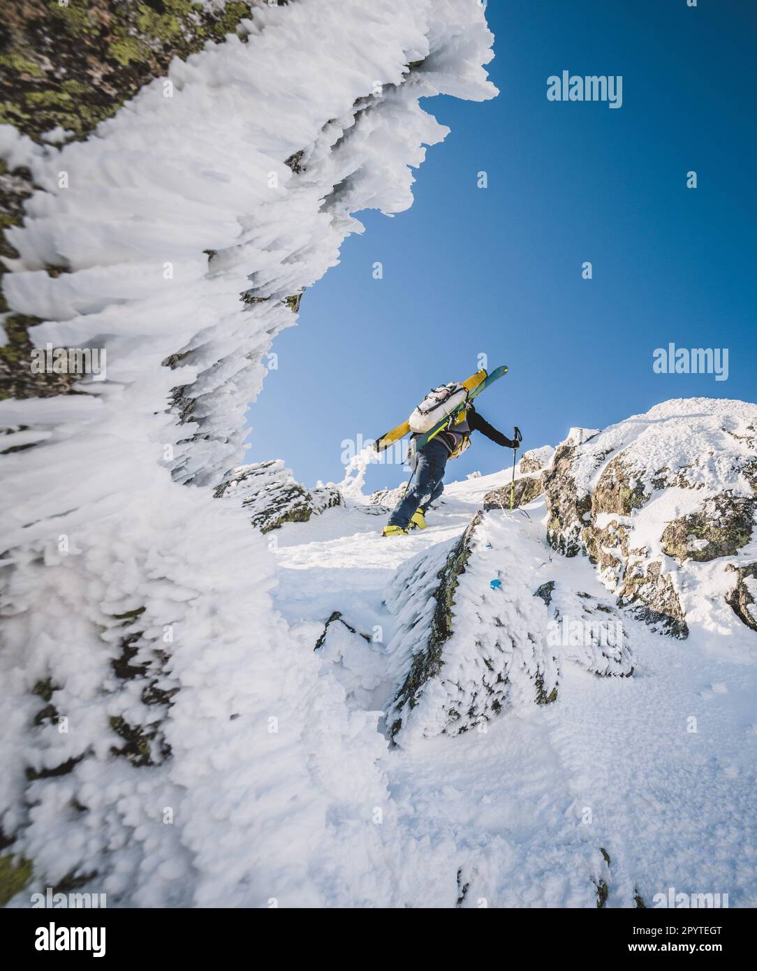 Wanderer mit Skiern klettern durch verschneites Eis und Felsen auf Katahdin, Maine Stockfoto