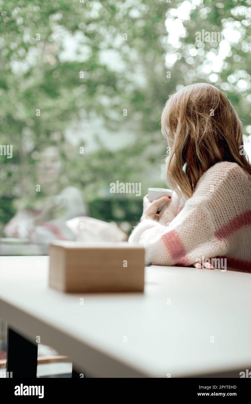 Eine Person schaute aufmerksam aus dem Fenster. Stockfoto