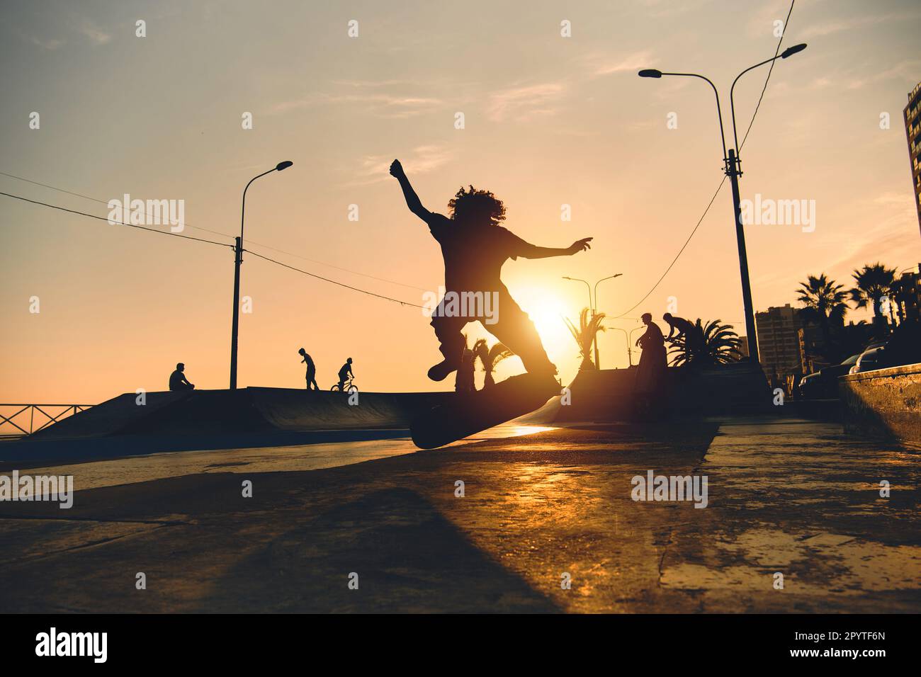Ein Gruppenjunge auf Skateboard im Sommer, die Silhouette ist nicht zu erkennen. Stockfoto