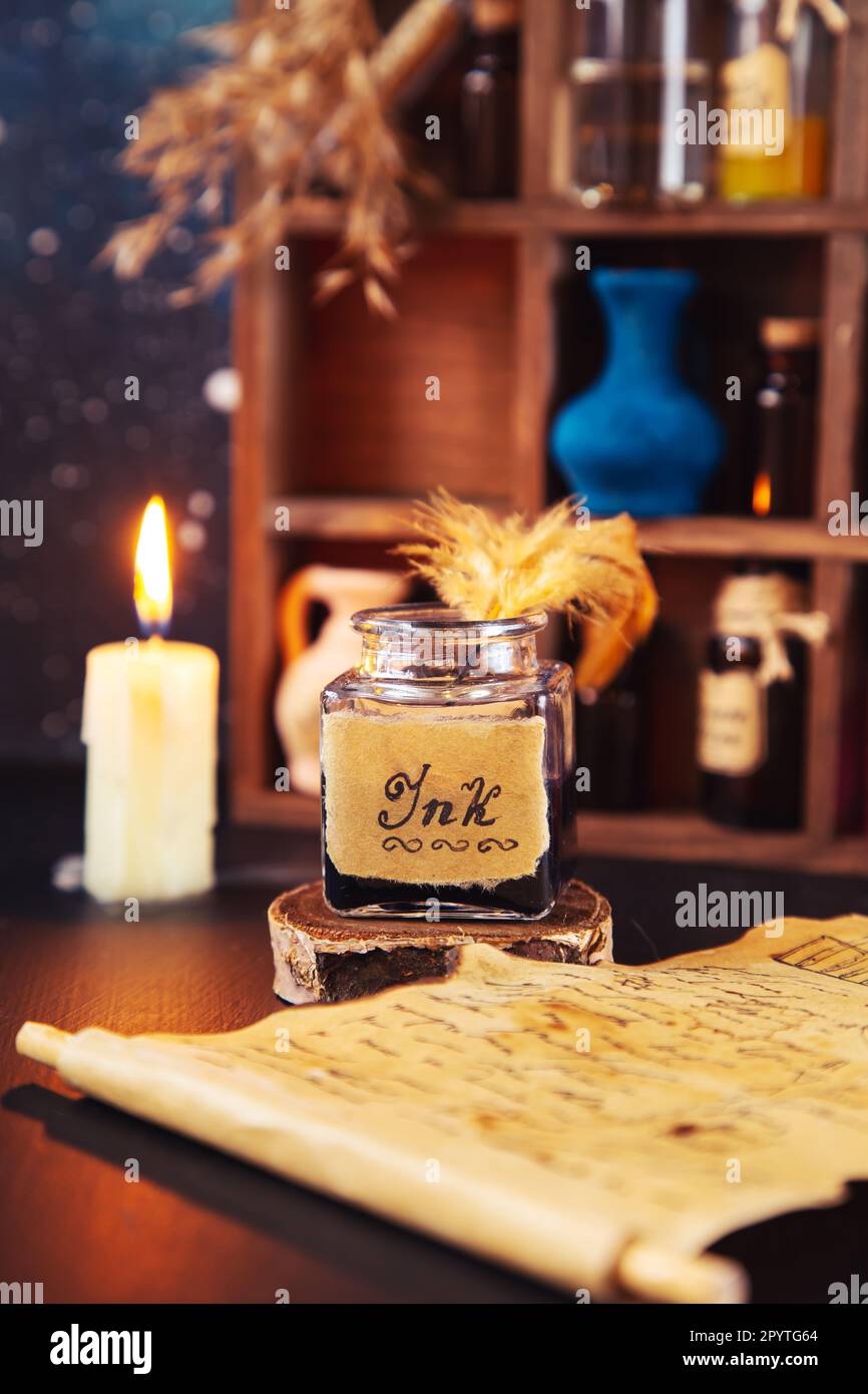 Antike Tinte mit Feder und Pergament. Im Hintergrund befindet sich ein Holzständer mit Flaschen und Tränken. Stockfoto