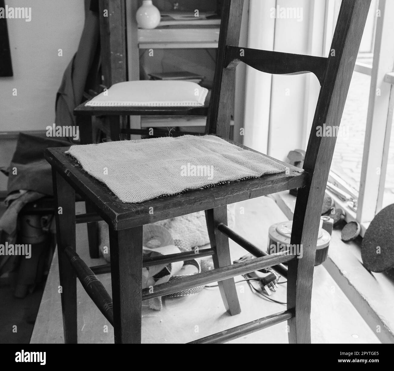 Polster fixiert einen neuen Riemen mit Hammer und Nägeln, um einen alten  Stuhl in seiner Werkstatt zu restaurieren, traditionelle Handwerkskunst,  Kopierraum, Bewegungsunschärfe, Select Stockfotografie - Alamy