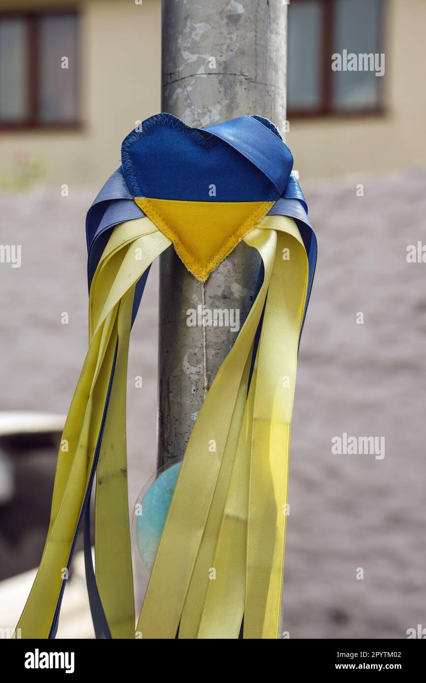 Aufrechtes Bild von "Ich liebe die Ukraine". Das Herz aus Stoff mit blauen und gelben Bändern, die an einer Stange befestigt sind, zeigt den Halt Stockfoto