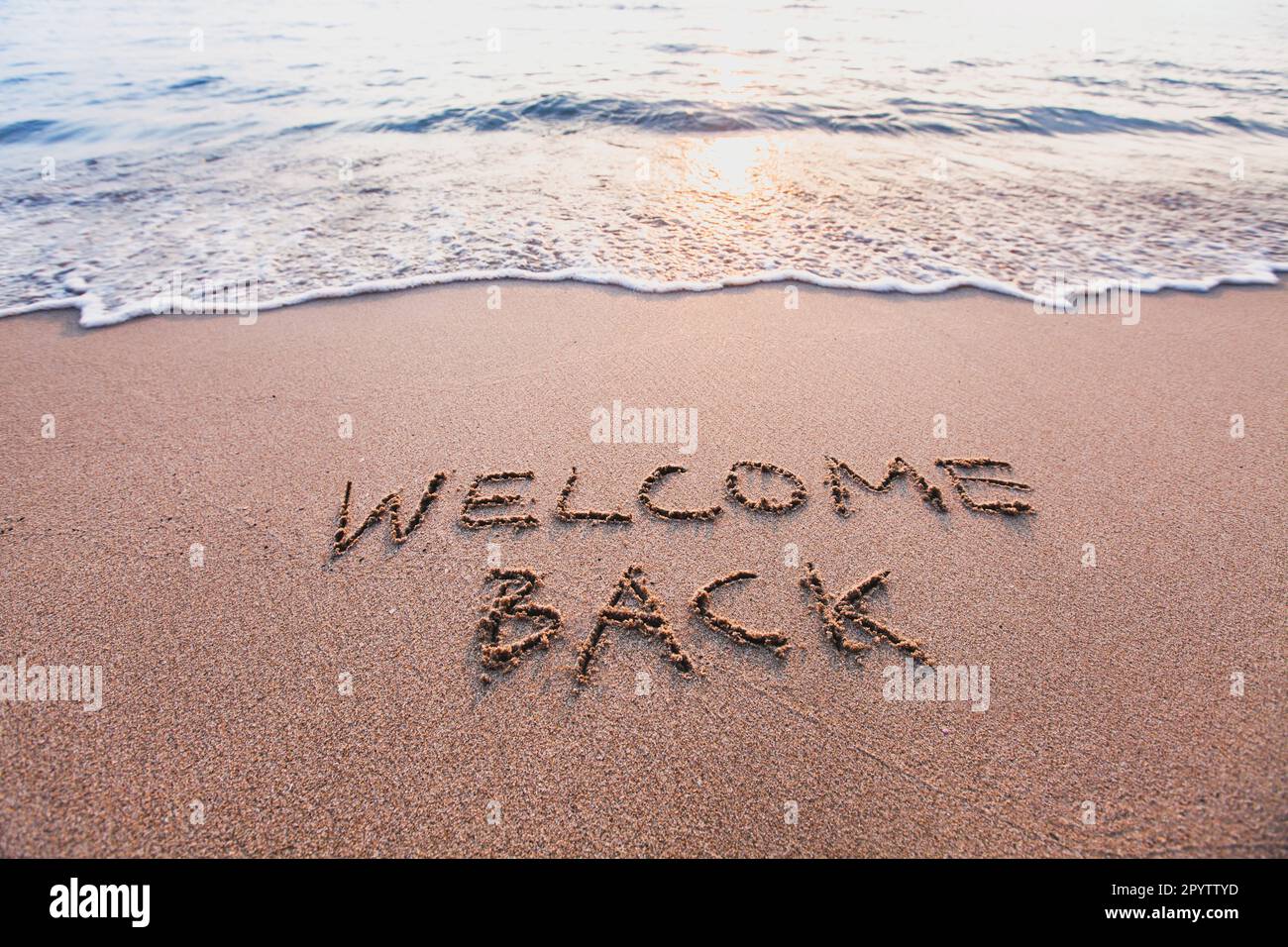Willkommen zurück, Text über Sandstrand, Tourismus nach Pandemie-Konzept Stockfoto Willkommen zurück, Text über Sandstrand, Tourismus nach Pandemie-Konzept Stockfoto