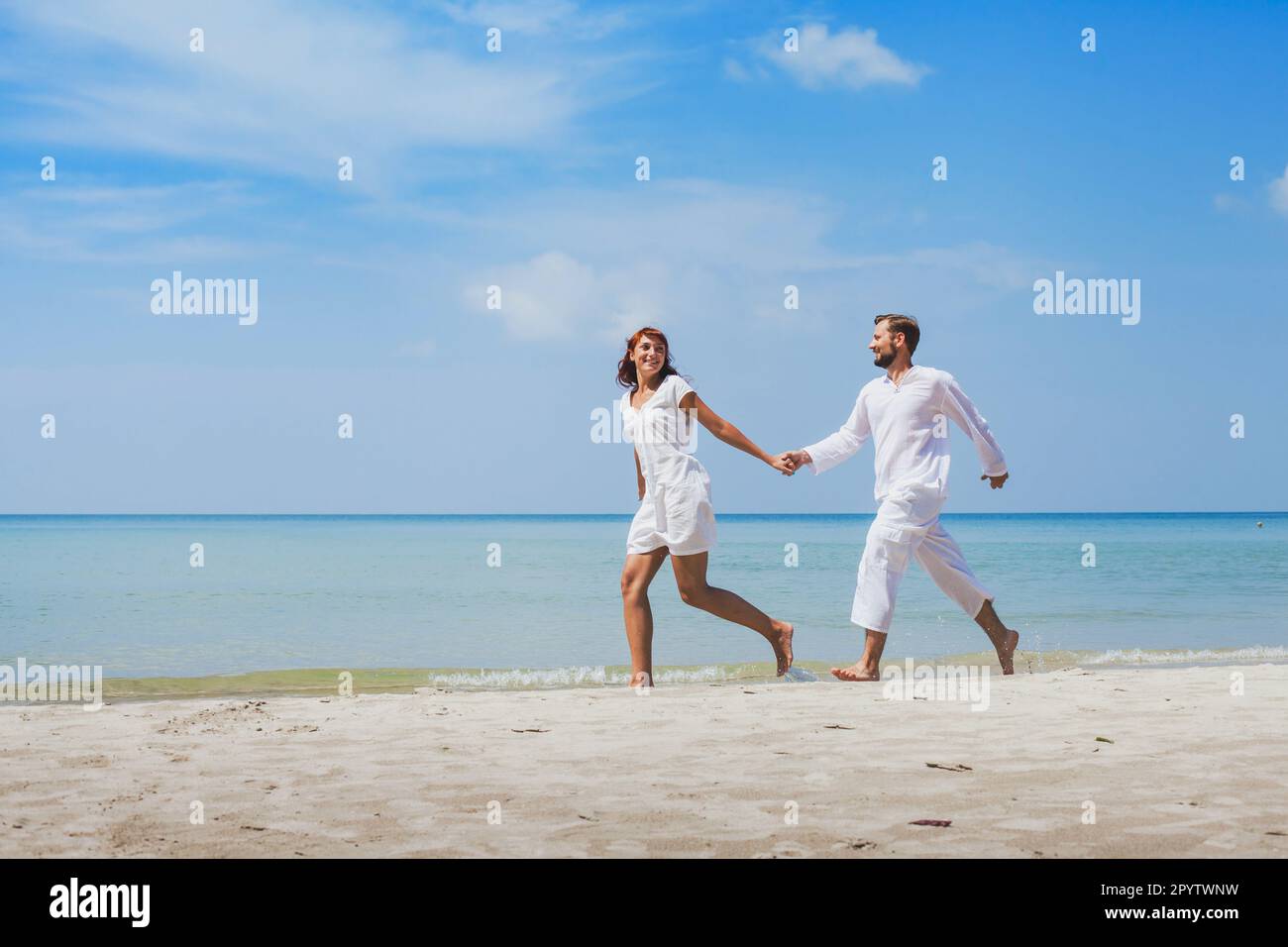 Flitterwochen am Strand, Tropenurlaub für Paare, Urlaub auf dem Meer, Mann und Frau gehen zusammen, halten Händchen, tragen weiße Kleidung Stockfoto Flitterwochen am Strand, Tropenurlaub für Paare, Urlaub auf dem Meer, Mann und Frau gehen zusammen, halten Händchen, tragen weiße Kleidung Stockfoto