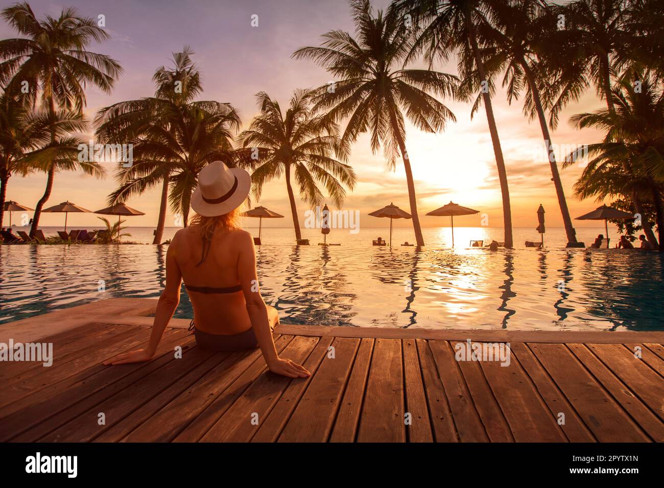 Strandurlaub im Luxushotel, tropischer Urlaub im Luxusresort, Frau sitzt am Pool Stockfoto Strandurlaub im Luxushotel, tropischer Urlaub im Luxusresort, Frau sitzt am Pool Stockfoto