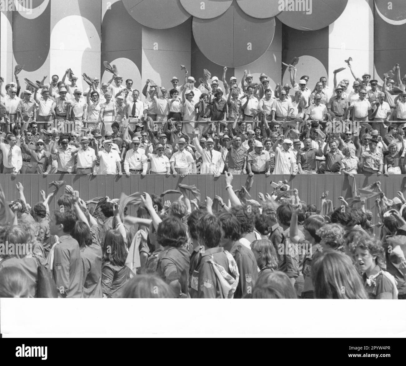 Demonstration des FDJ. FDJ-Mitglieder winken, während sie das Funktionspräsidium passieren, mit Erich Honecker in der Mitte. Nationales Jugendfestival der DDR in Berlin. Partei. SED. Festival. Ereignis. Tribun. Jugend. Jugend. Foto: MAZ/Gerhar Murza, Juni 1979 [automatisierte Übersetzung] Stockfoto