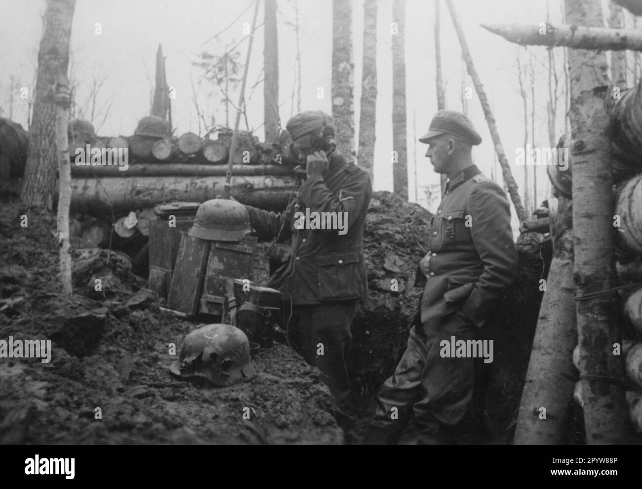 Funker an einem Kommandostand an der Ostfront bei Mostki. Im Vordergrund ein Schuss durch einen Stahlhelm. Foto: Schmidt-Scheeder. [Maschinelle Übersetzung] Stockfoto