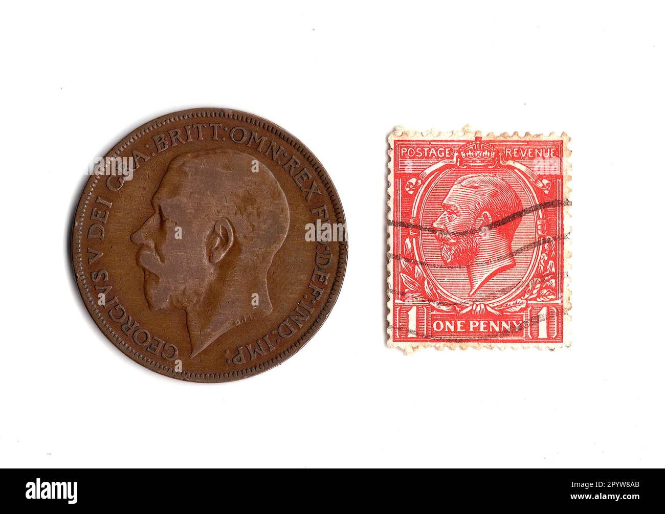 Eine Penny Münze und eine Briefmarke aus der Herrschaft von König George V. isoliert auf weißem Hintergrund. Stockfoto