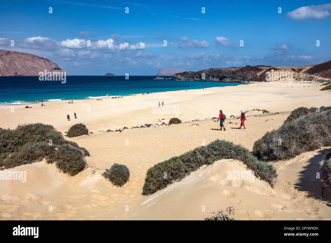 Spanien, Kanarische Inseln, Insel Lanzarote, Insel La Graciosa. Las Conchas Strand. Klettervulkan. Badende und Wanderer. Stockfoto