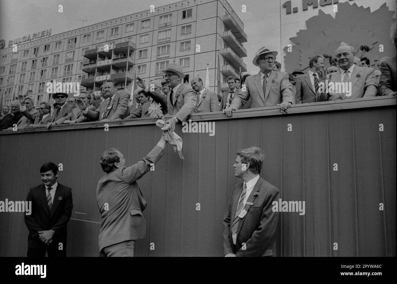 DDR, Berlin, 01.05.1987, 1. Mai Rallye 1987 auf der Karl-Marx-Allee, Tribun, Erich Honecker is Hands Flowers, Left: Günter Schabowski, Horst Sindermann (2. von rechts), Harry Tisch (1. von rechts), Wachen, Personal Security, [automatisierte Übersetzung] Stockfoto