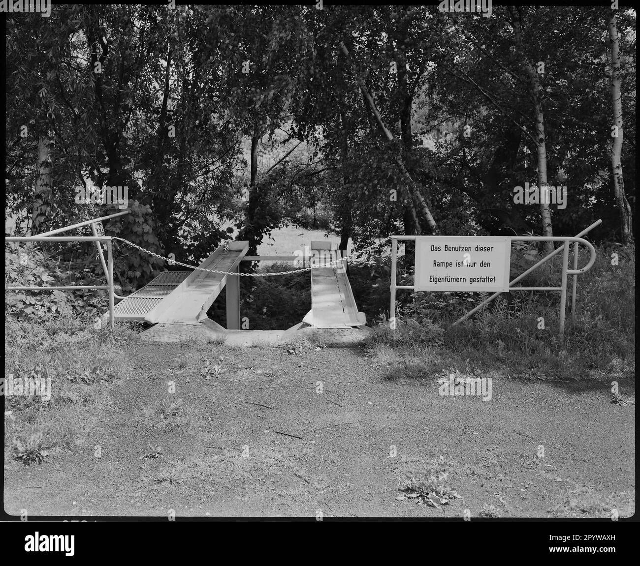 ' Rampe für Autos umgeben von Natur. Davor ein Schild mit der Aufschrift „nur die Besitzer dürfen diese Rampe benutzen“. Wildau (Bezirk Dahme-Spreewald, Brandenburg), Foto, 1994." Stockfoto