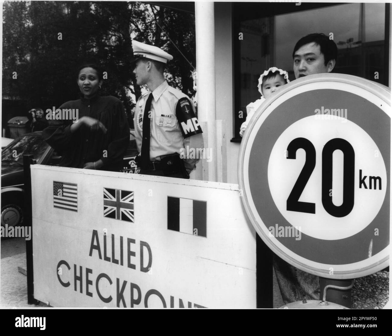 Berlin, Checkpoint Charlie, Friedrichstraße. Am 22. Juni 1990 wurde der Kontrollpunkt im Rahmen einer Gedenkfeier (Militärzeremonie) aufgelöst. Besucher neben einem amerikanischen Grenzschutz. Schwarz-Weiß. Foto, 06-22-1990. Stockfoto
