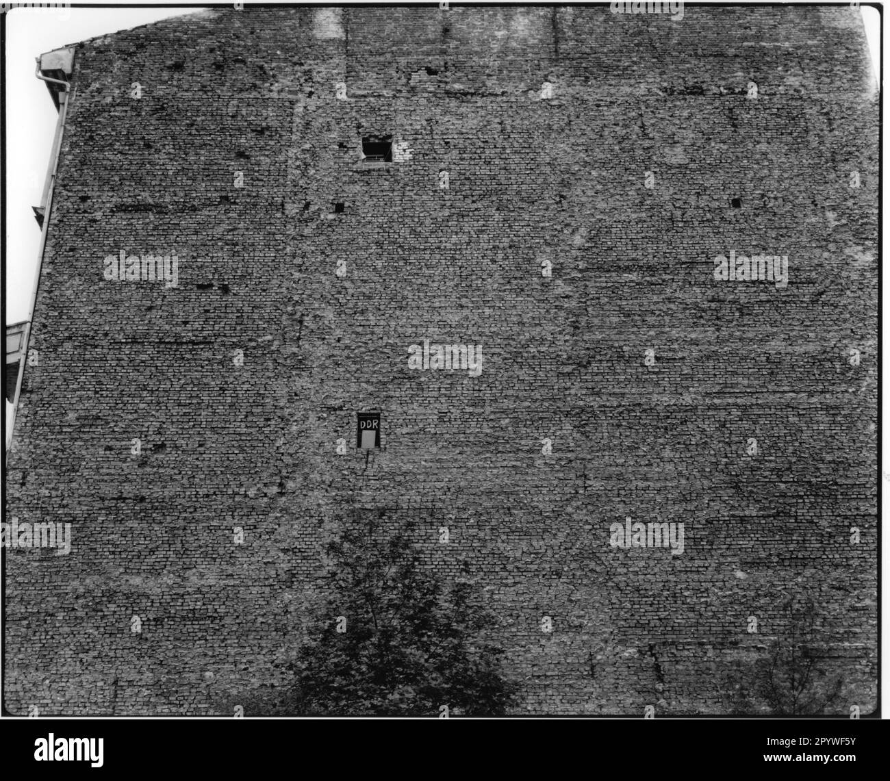 Ostberlin. Blick von Westberlin auf die Mauer eines Hauses. Fenster mit der Aufschrift „DDR“. Blick auf die Stadt, schwarz-weiß. Foto, 1992. Stockfoto