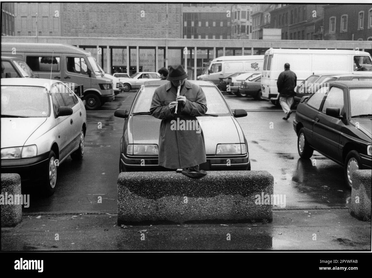 Lüttich (Belgien), Straßenmusik, Flötenspieler. Ein Mann spielt Flöte auf einem Parkplatz. Straßenszene, schwarz-weiß. Foto, 1993. Stockfoto