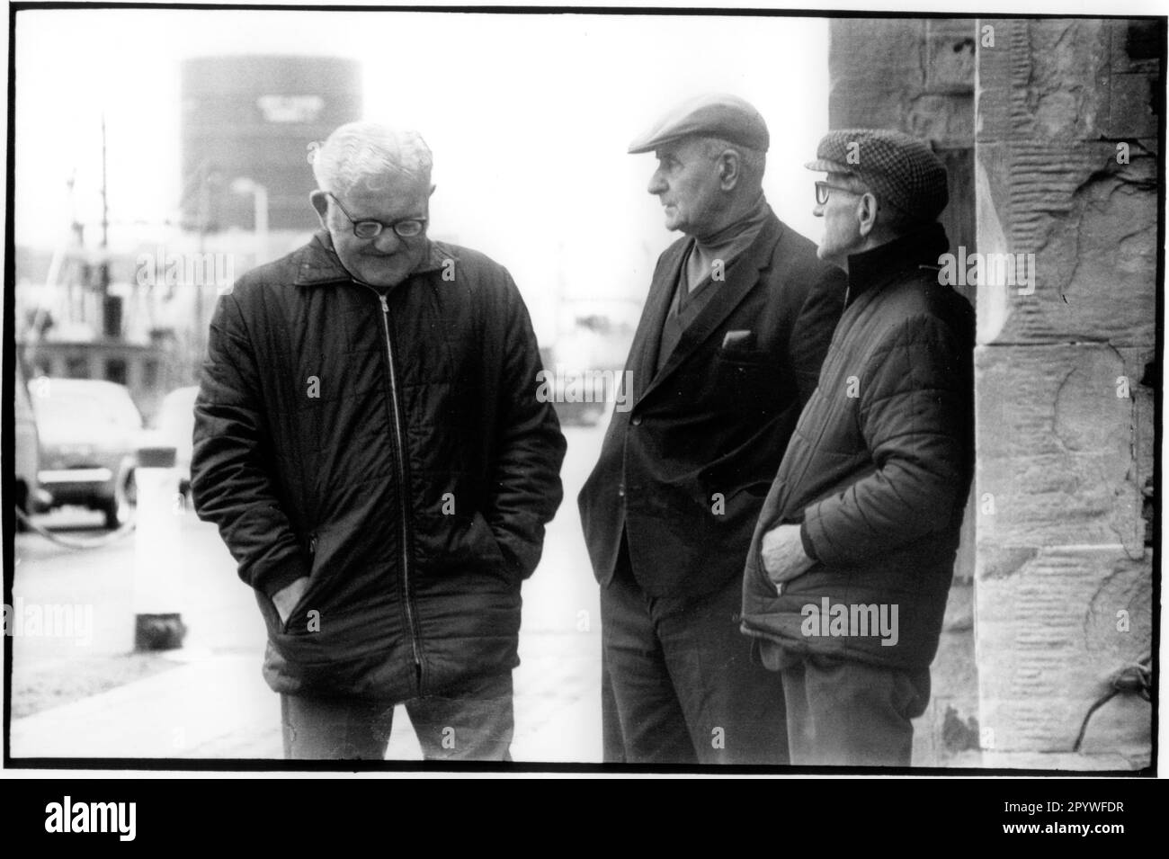 Kirkwall (Festland, Orkney Islands, Schottland), Men at the Harbor. 3 Männer stehen zusammen auf der Straße. Straßenszene, schwarz-weiß. Foto, 1992. Stockfoto