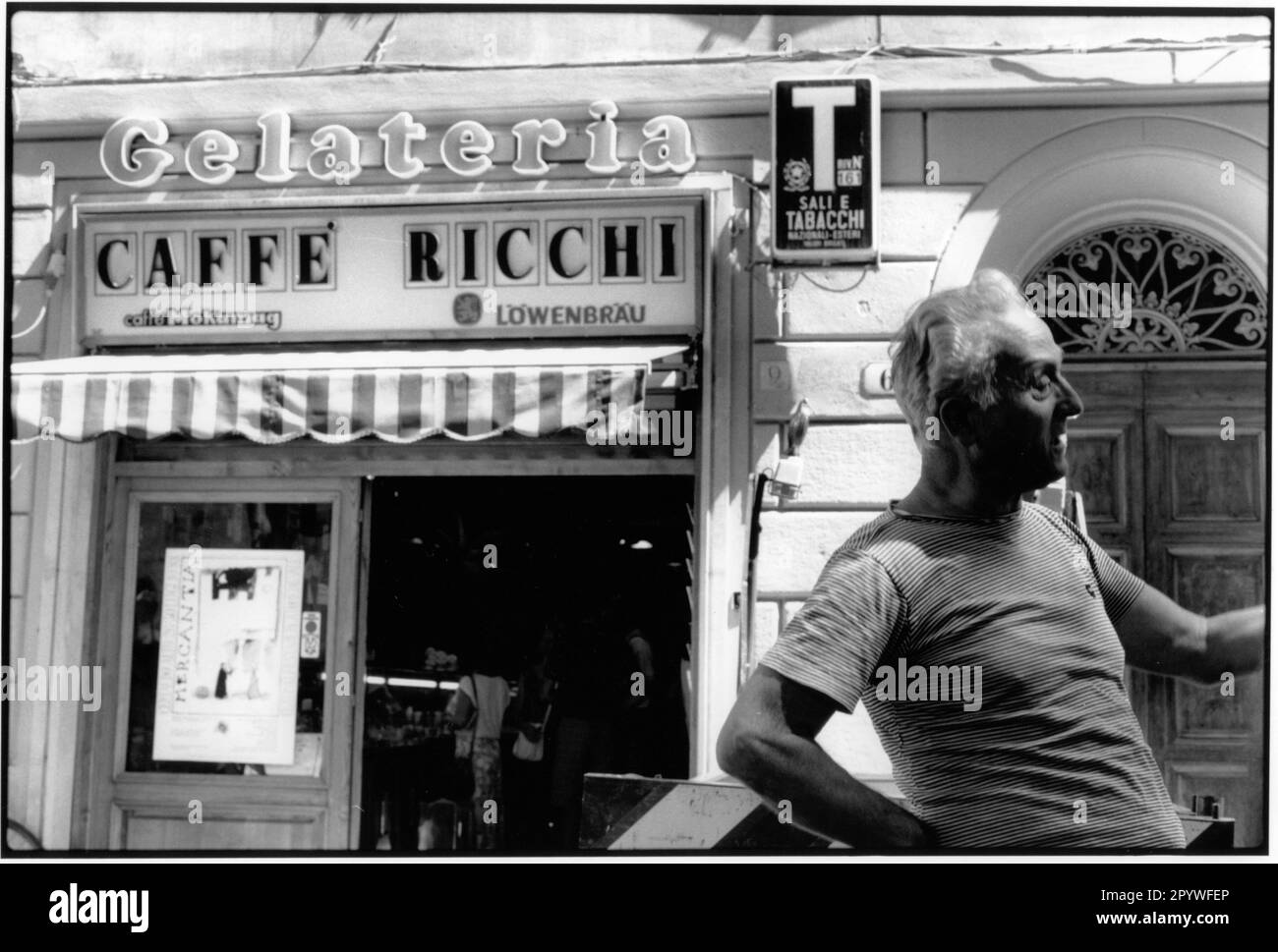 Florenz, Florenz (Toskana, Italien). Blick auf die Straße: Caffé Ricchi, Gelateria und Sali e Tabacchi, vor ihnen ein Mann auf der Straße. Straßenszene, schwarz-weiß. Foto, 1992. Stockfoto