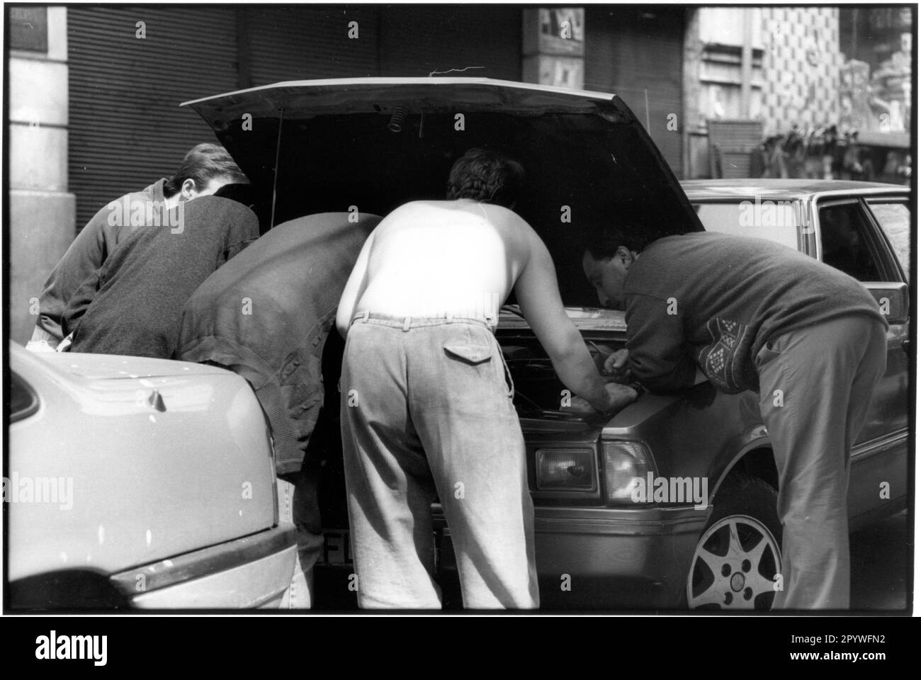 „Istanbul (Türkei). Straßenszene: „Car Love“ 5 Männer beugen sich über den Motor eines Autos. Schwarz-Weiß. Foto, 1994. Stockfoto