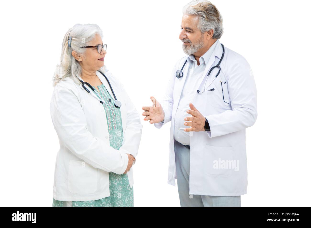 Senior indische männliche und weibliche Ärztin diskutiert isoliert über weißen Hintergrund, Gesundheitskonzept. Stockfoto