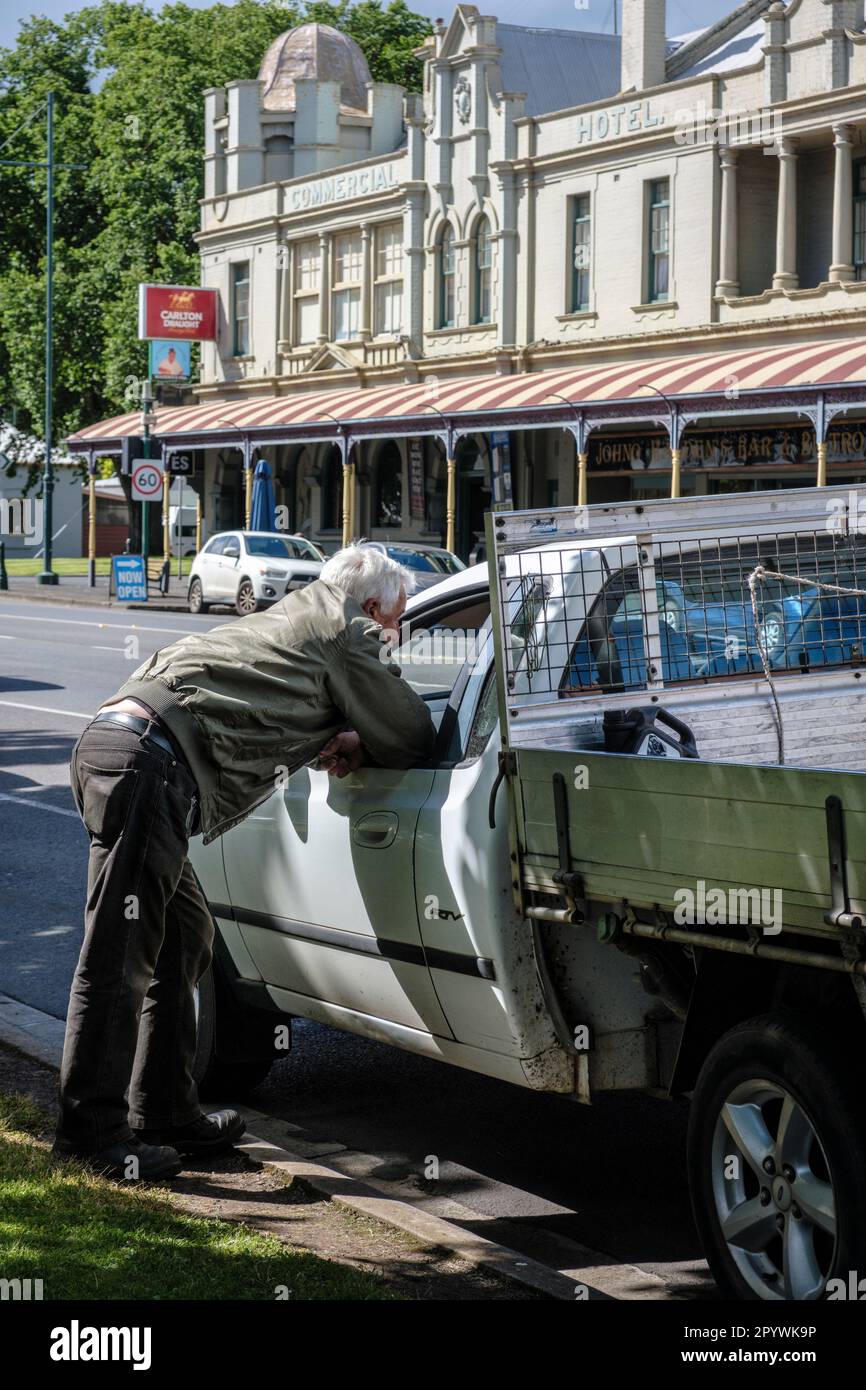 Ein Mann lehnt sich in ein Autofenster, um mit einem Kumpel zu plaudern, Camperdown, Victoria, Australien Stockfoto