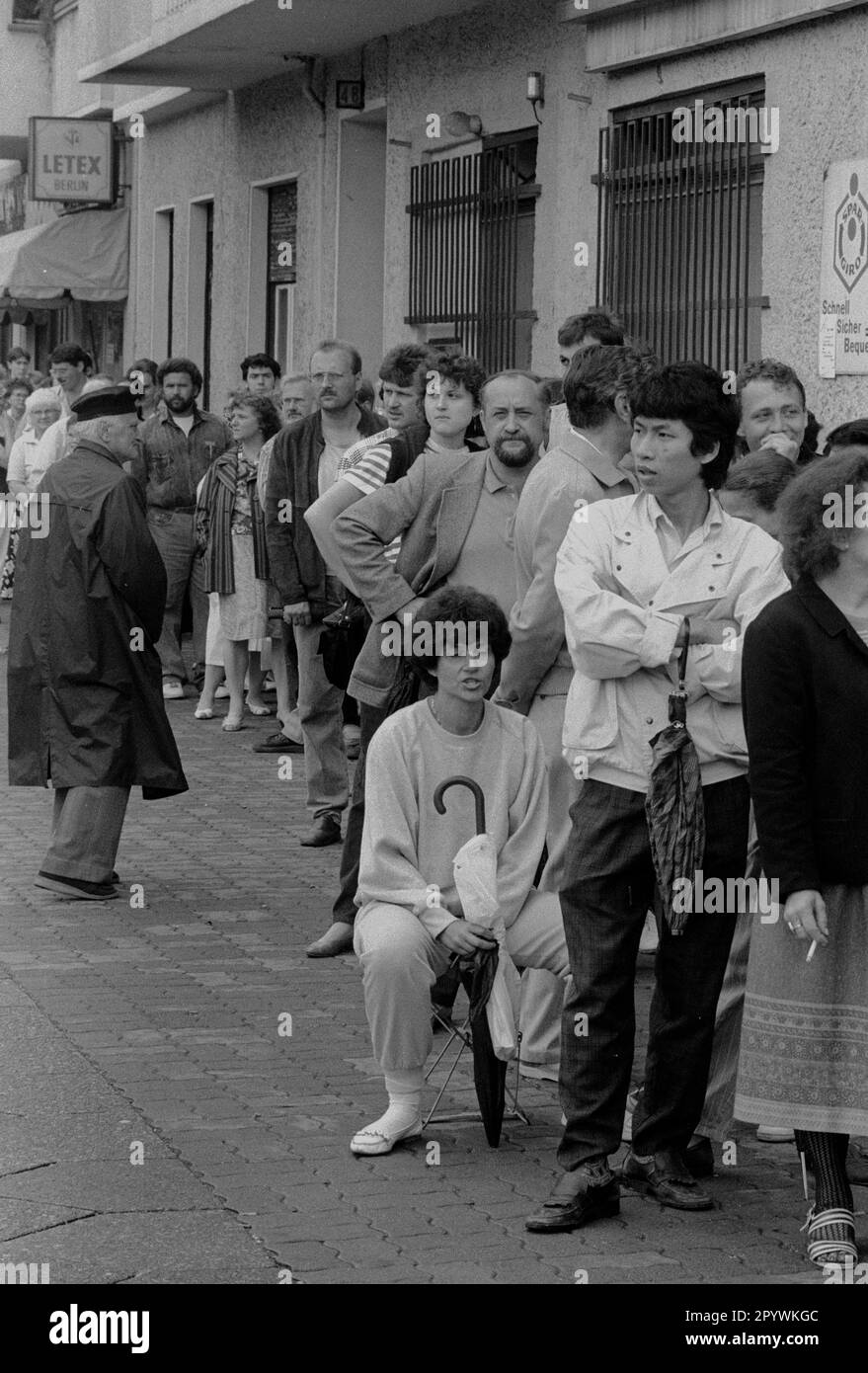 Berliner Bezirke / Prenzlauer Berg / 1990 Austausch der DDR-Marke gegen DM. Die Bürger der DDR mussten ein Konto eröffnen und im Vorfeld einen Antrag stellen. Hier kriegen sie D-Mark und in drei Monaten ist es mit der DDR vorbei. // DM / Wechselkurs / Währungsunion / Vereinigung // Distrikte / *** Lokale Beschriftung *** Vereinigung / Ostdeutschland / Alle Bürger des kommunistischen Deutschlands könnten eine bestimmte Menge Ostdeutscher Mark in Westdeutsche Mark umwandeln. Schlange vor einer Sparkasse. [Maschinelle Übersetzung] Stockfoto