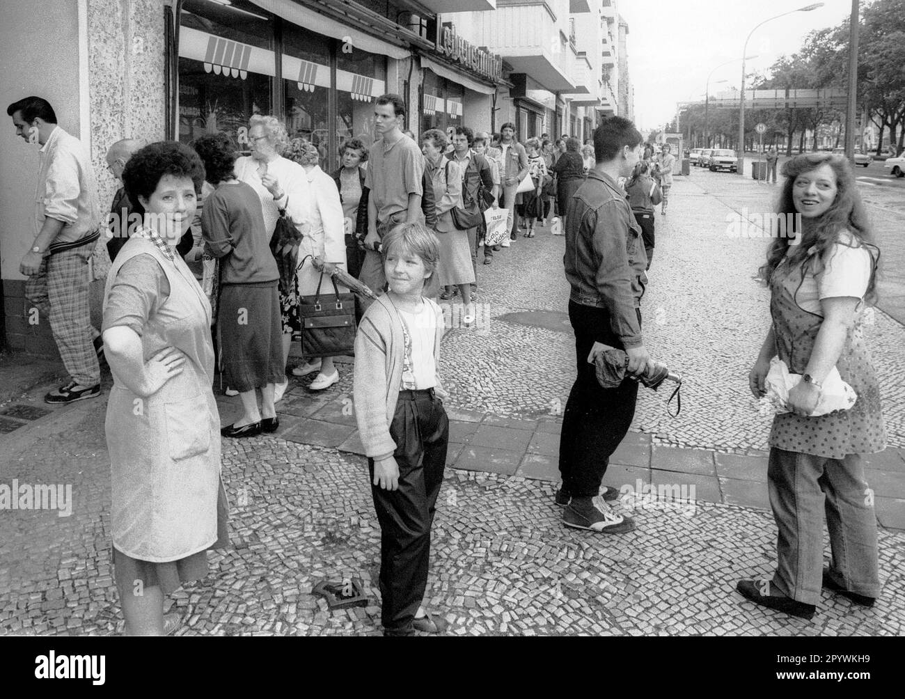 Berliner Bezirke / Prenzlauer Berg / 1990 Austausch der DDR-Marke gegen DM. Die Bürger der DDR mussten ein Konto eröffnen und im Vorfeld einen Antrag stellen. Hier kriegen sie D-Mark und in drei Monaten ist es mit der DDR vorbei. Prenzlauer Berg, Ecke Greifswalder Straße // DM / Wechselkurs / Währungsunion / Vereinheitlichung // Bezirke / *** Lokale Beschriftung *** Vereinheitlichung / Ostdeutschland / Alle Bürger des kommunistischen Deutschlands könnten eine bestimmte Menge Ostdeutscher Mark in Westdeutsche Mark umwandeln. Schlange vor einer Sparkasse. [Maschinelle Übersetzung] Stockfoto