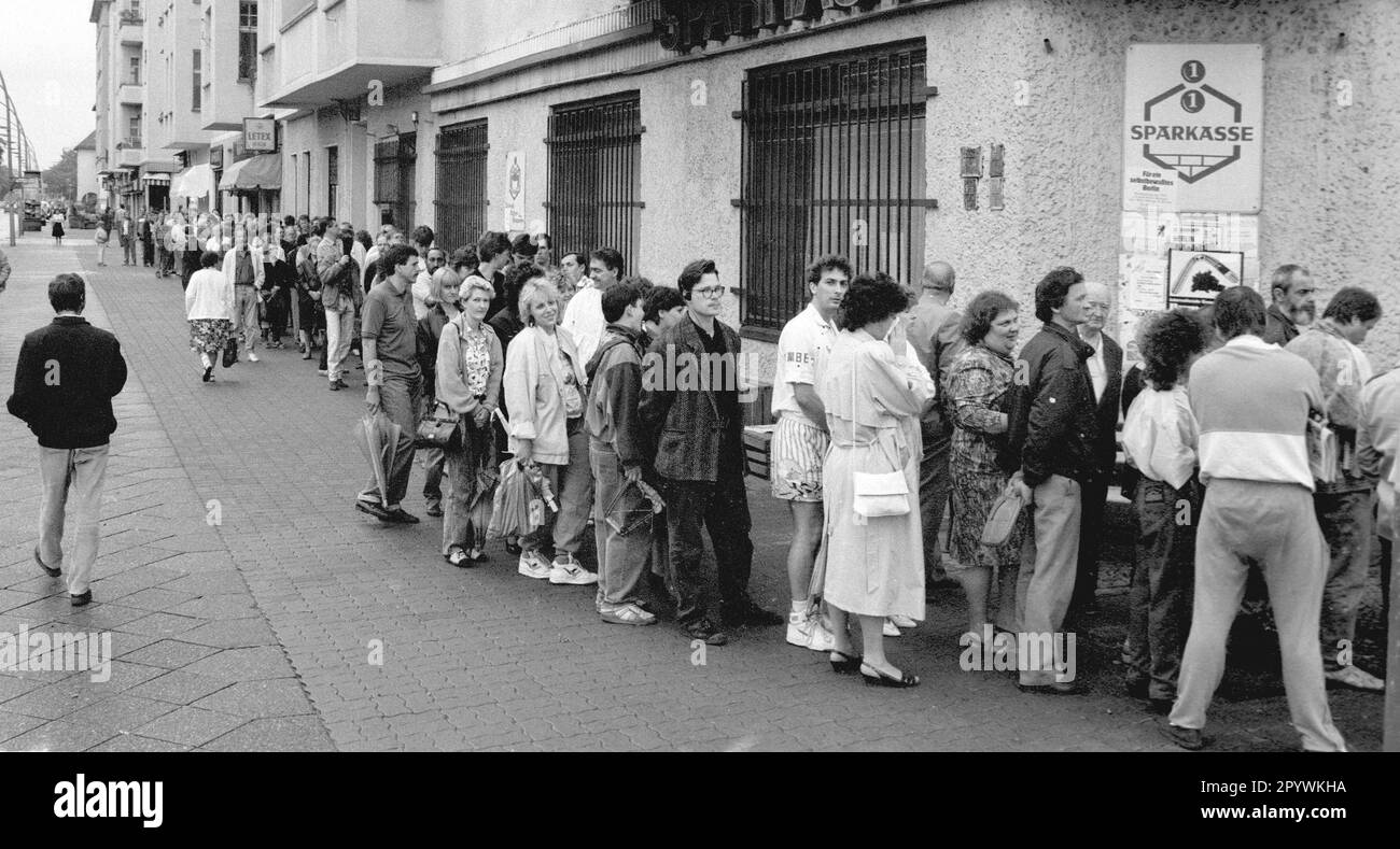 Berliner Bezirke / Prenzlauer Berg / 1990 Austausch der DDR-Marke gegen DM. Die Bürger der DDR mussten ein Konto eröffnen und im Vorfeld einen Antrag stellen. Hier kriegen sie D-Mark und in drei Monaten ist es mit der DDR vorbei. Prenzlauer Berg, Ecke Greifswalder Straße // DM / Wechselkurs / Währungsunion / Vereinheitlichung // Bezirke / *** Lokale Beschriftung *** Vereinheitlichung / Ostdeutschland / Alle Bürger des kommunistischen Deutschlands könnten eine bestimmte Menge Ostdeutscher Mark in Westdeutsche Mark umwandeln. Schlange vor einer Sparkasse. [Maschinelle Übersetzung] Stockfoto