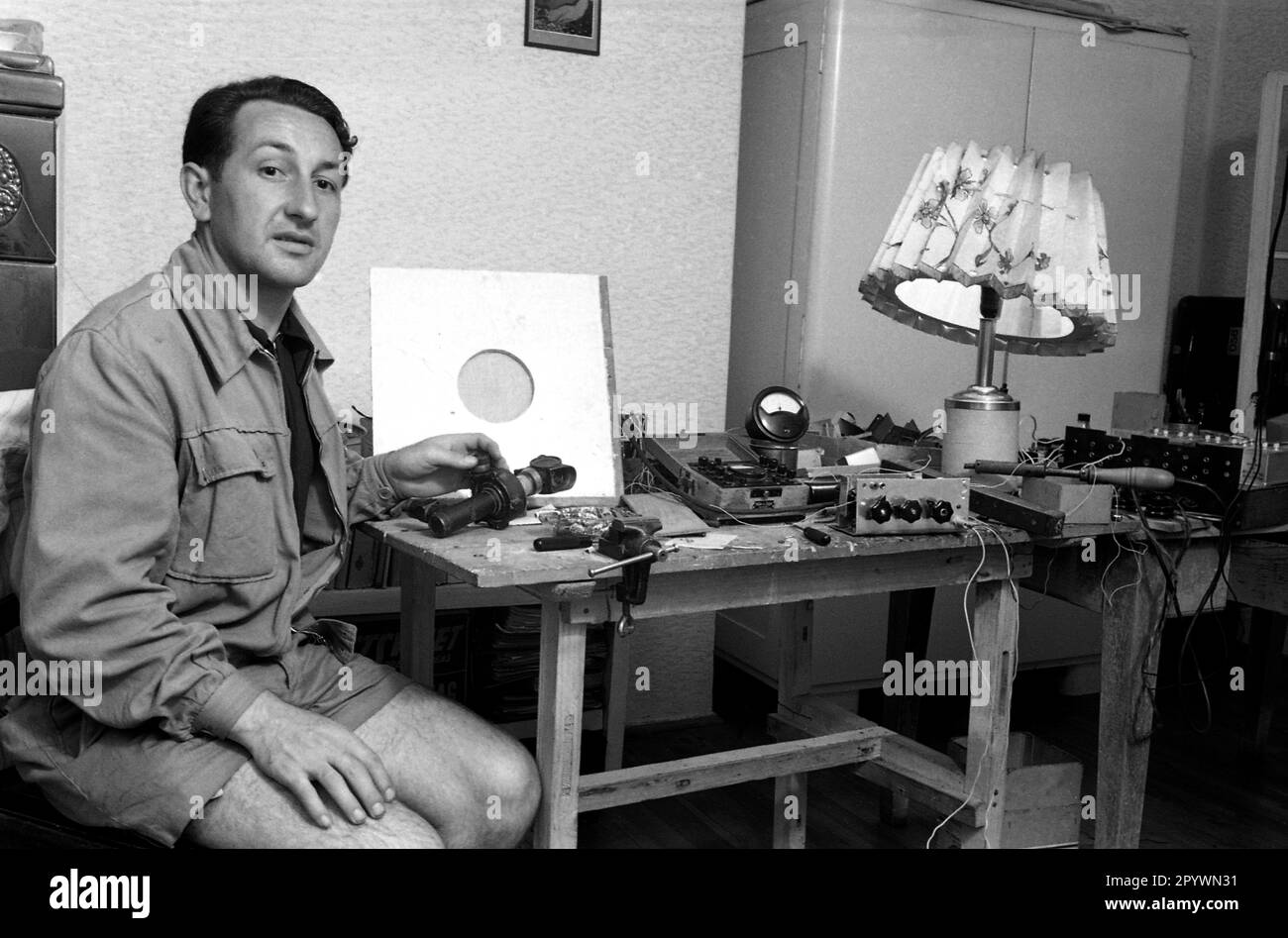 Ein Student an einer technischen Hochschule sitzt an einem Tisch mit auseinandergenommenen Funkgeräten. [Maschinelle Übersetzung] Stockfoto