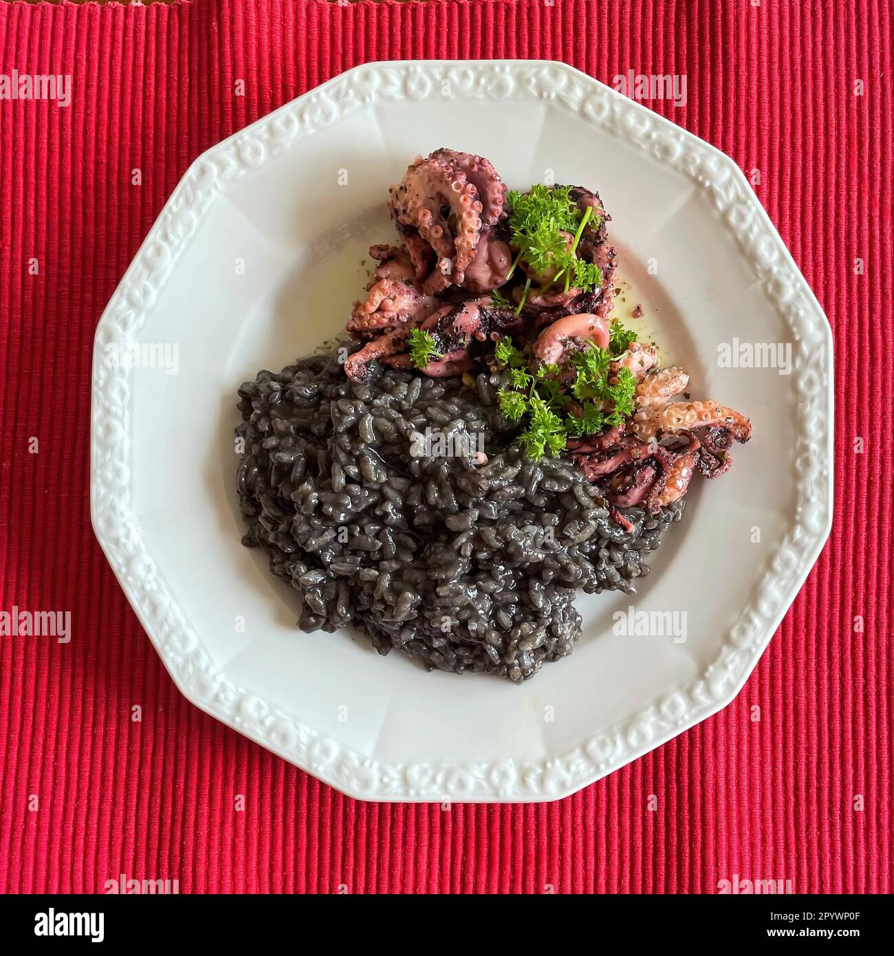 Italienisches Gericht der italienischen Küche Schwarzes Risotto nero mit Tintenfisch garniert mit Petersilie, Italien Stockfoto